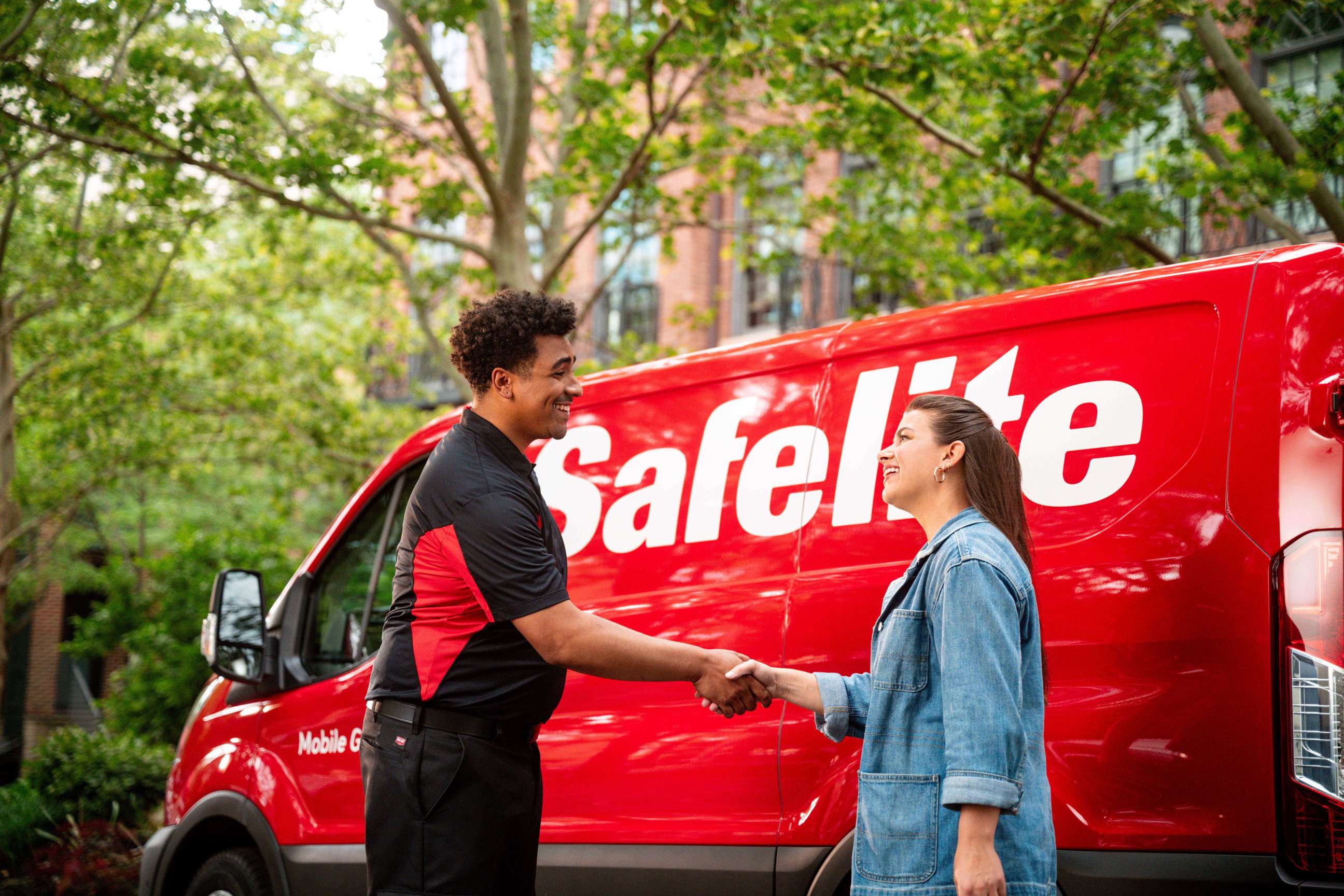 Safelite technician with customer in front of van