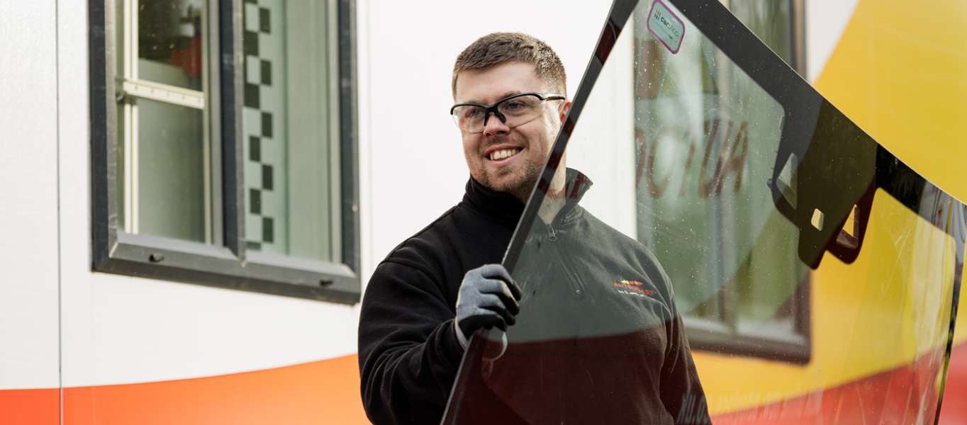 Technician carrying windscreen
